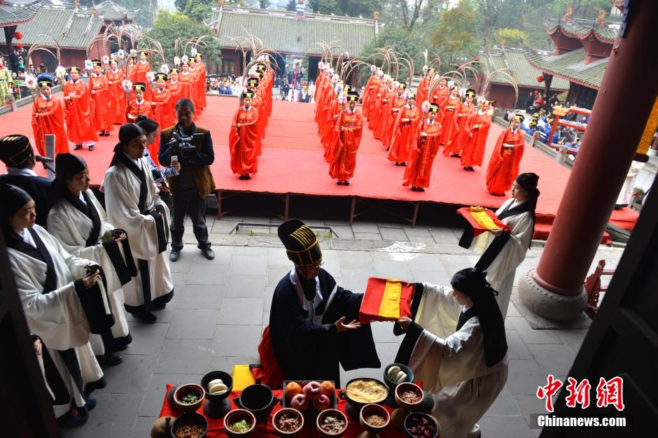 身着古代礼服的祭祀人员沿着青石台阶前行,擂鼓燃烛,舞乐声起,献供品